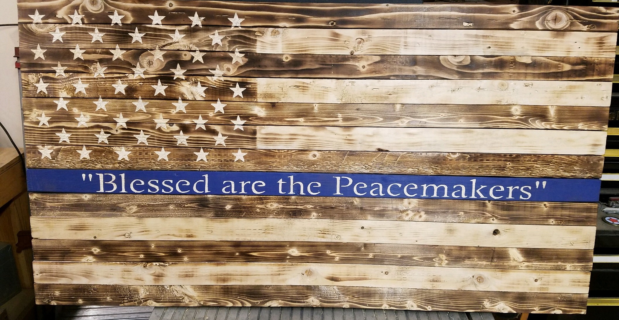 Picture of rustic flag with thin blue line painted across the middle.