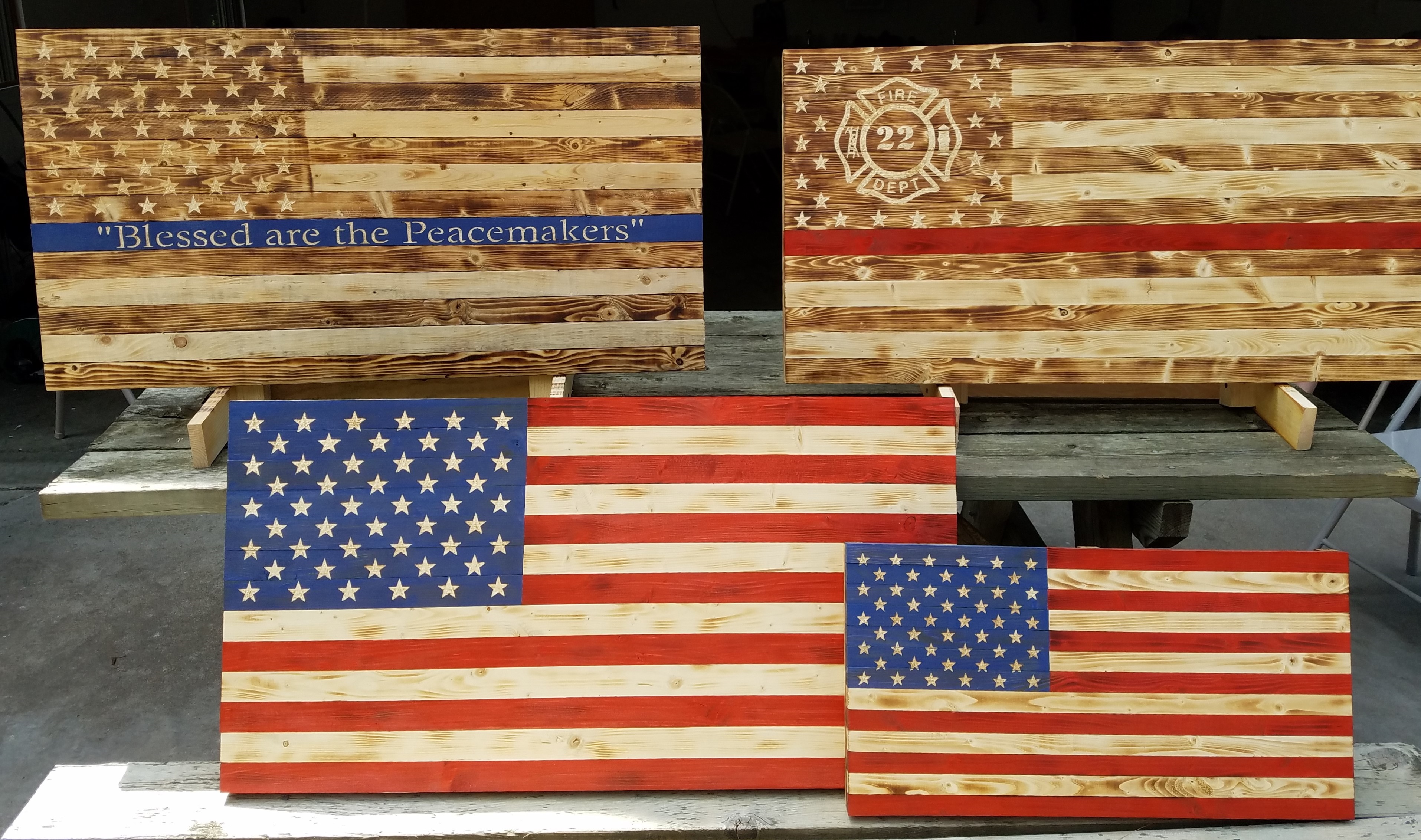 Picture of four flags: thin blue line, thin red line, small American flag, and large American flag.