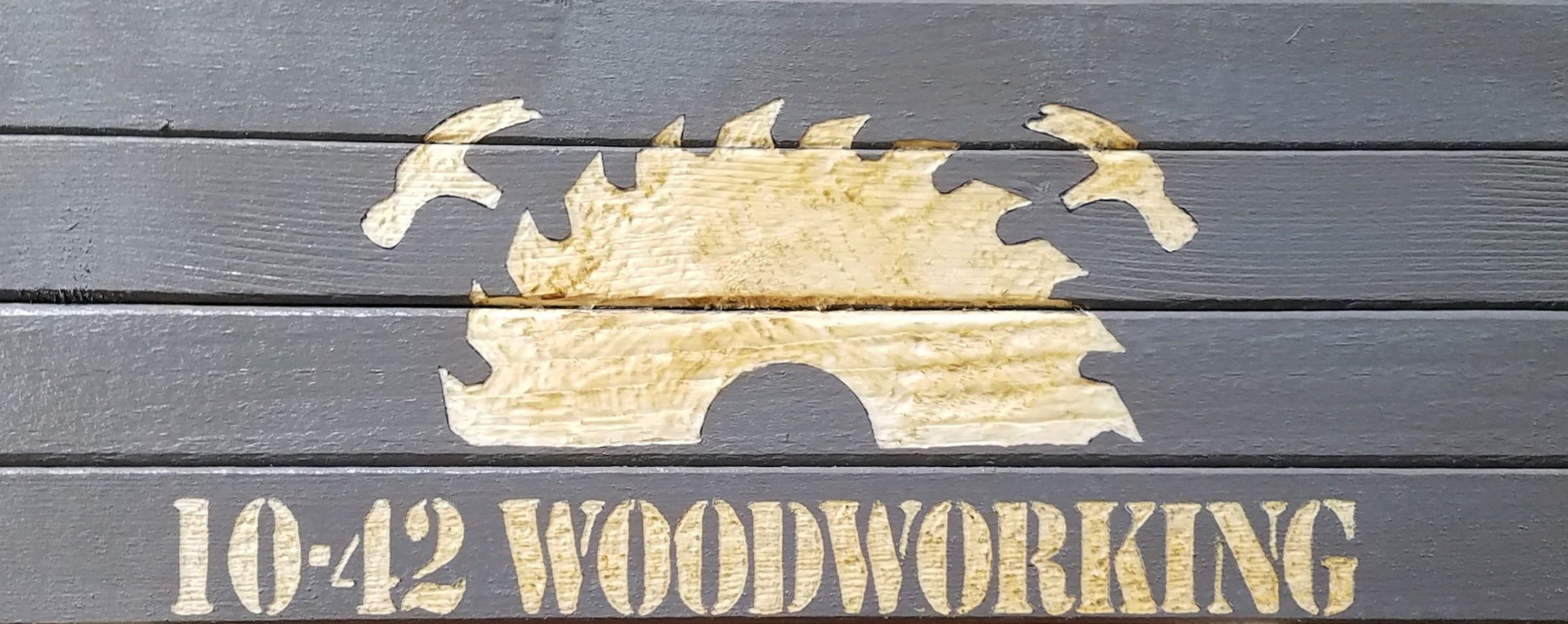 Picture of custom wood sign. Design is engraved and painted gray.