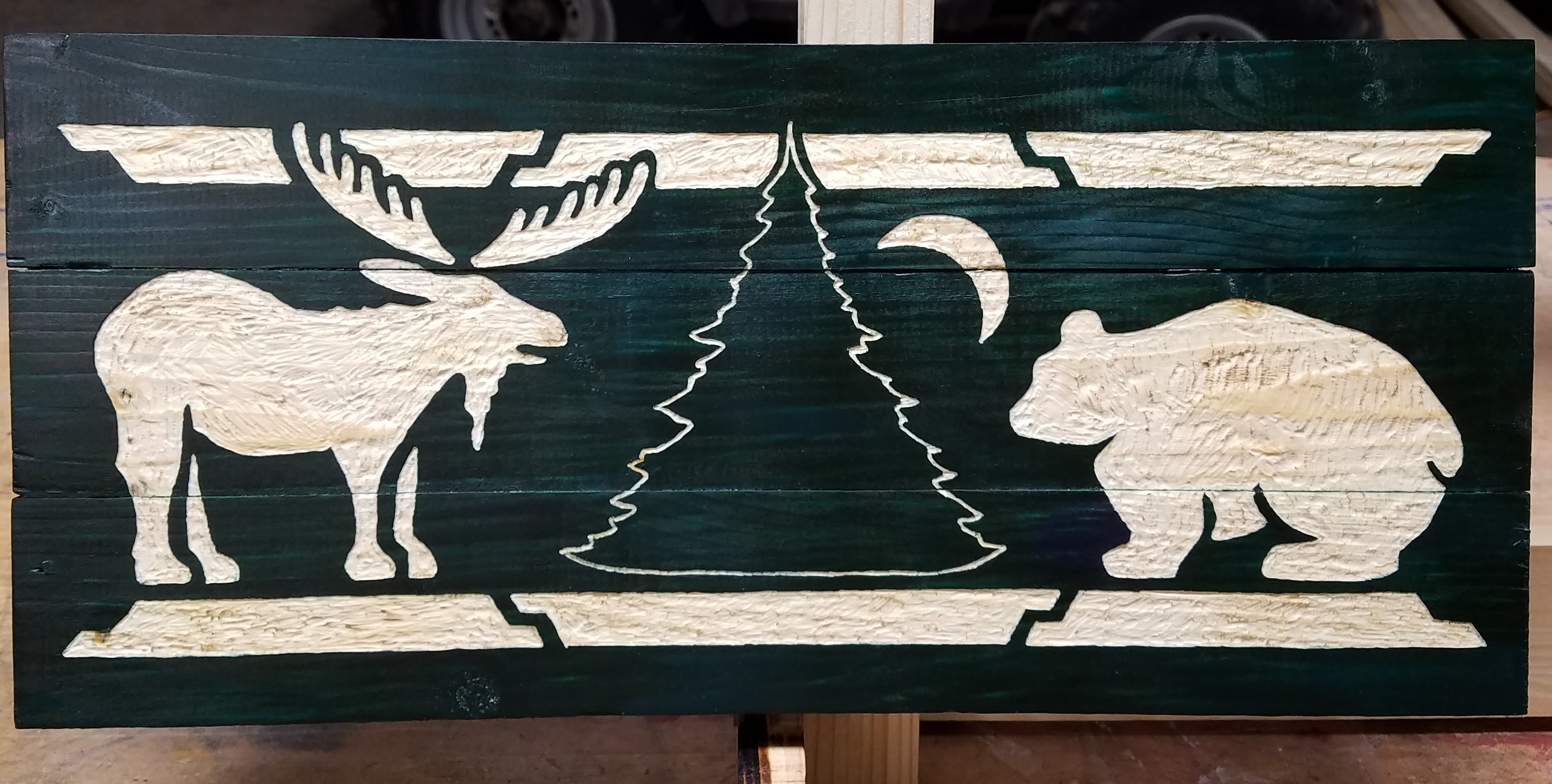 Picture of engraved and painted green wooden outdoor sign.