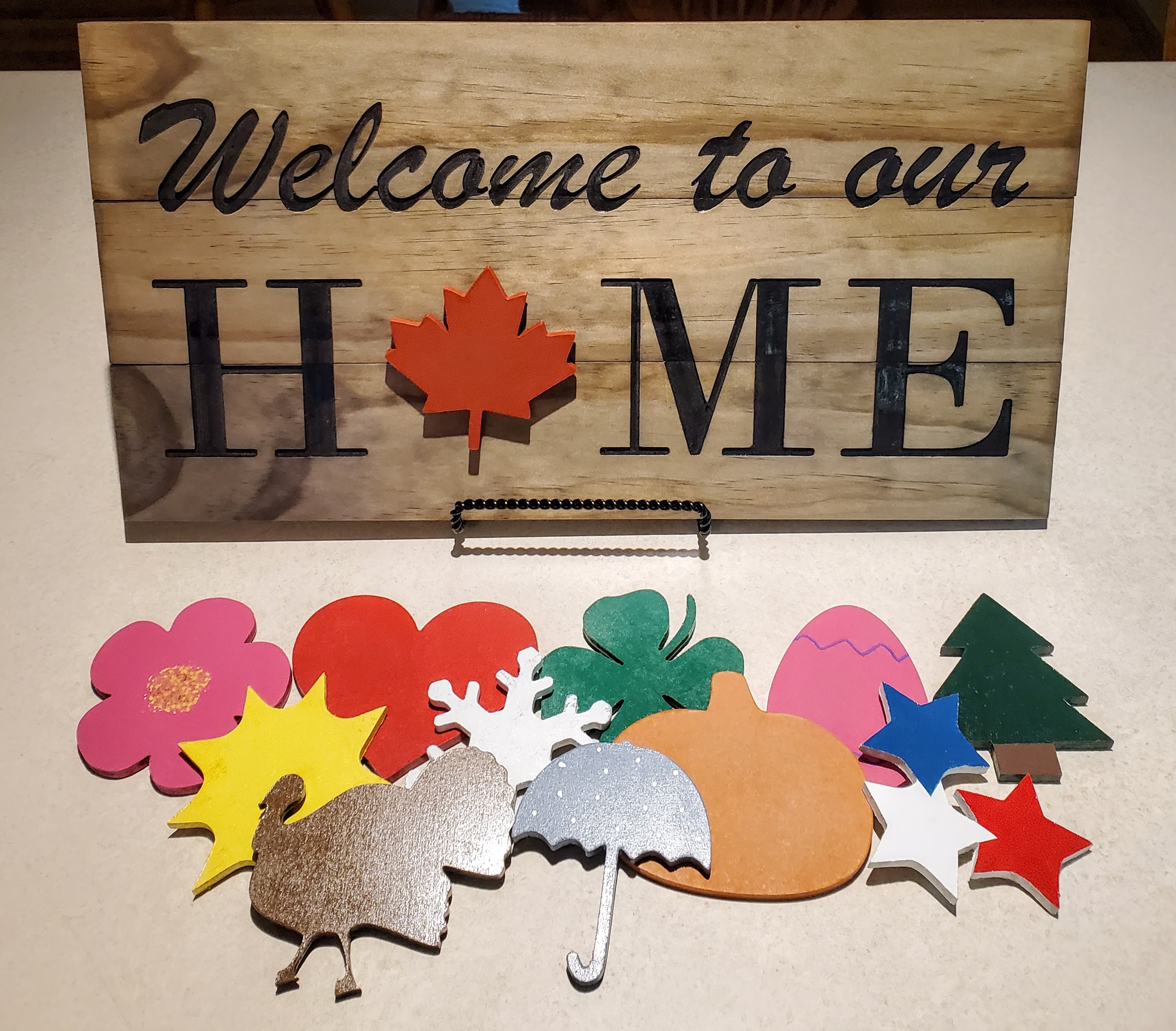 Picture of wooden 'Welcome to our Home' sign with 12 interchangable icons for the different seasons.