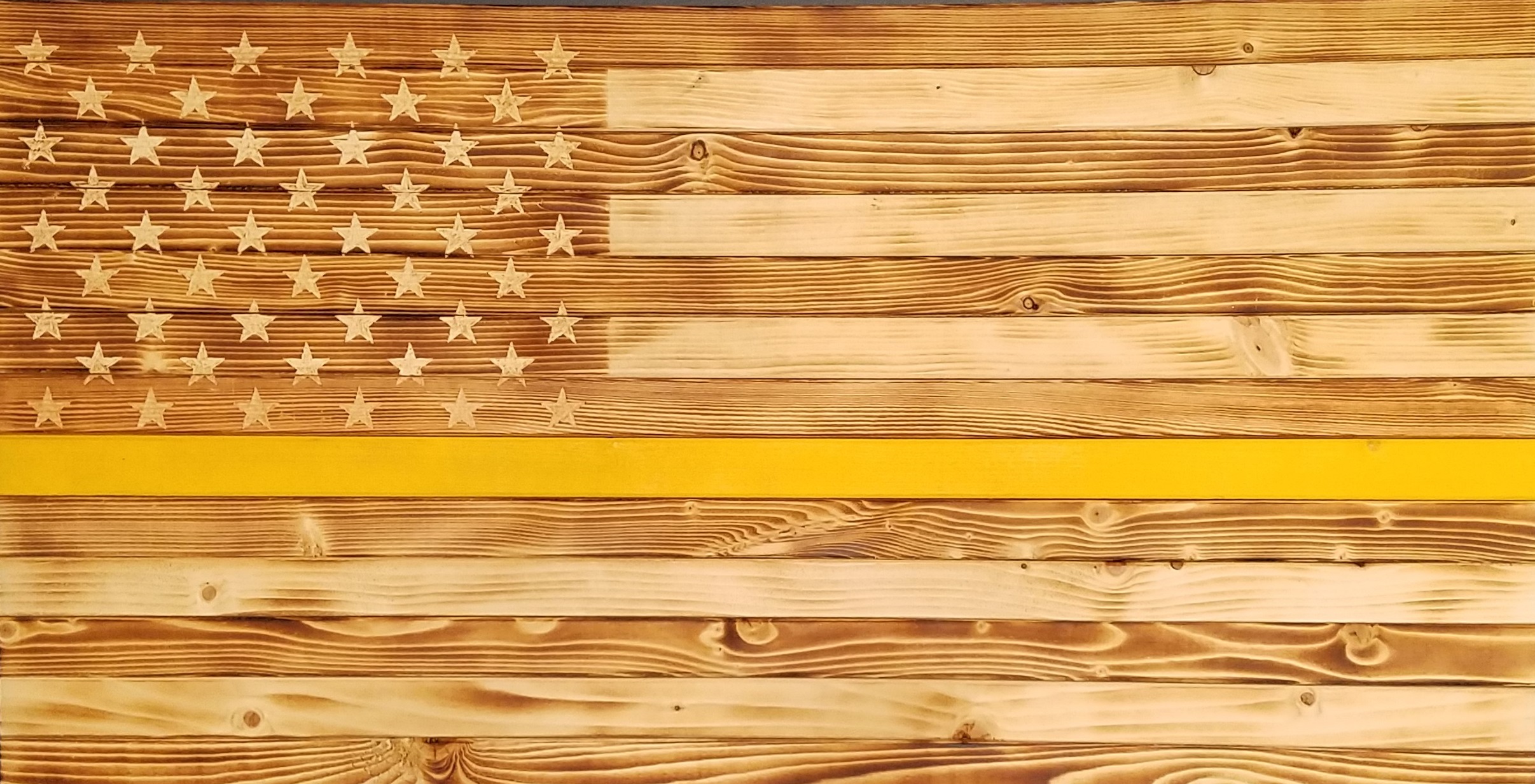 Picture of rustic, wooden flag with yellow stripe.